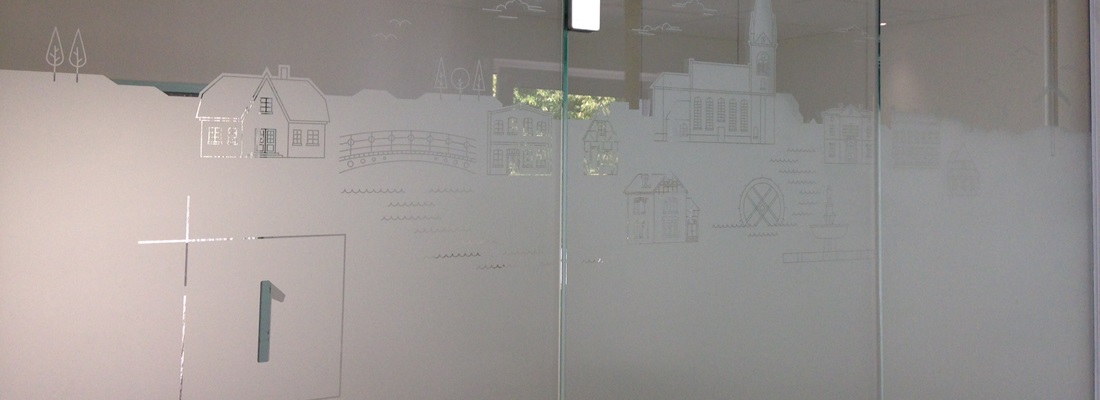 Glaswand mit Milchglasfolie und ausgestanzten Illustrationen von Gebäuden, Brücke und Kirche