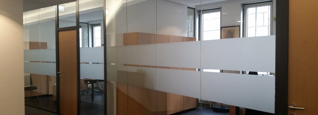 Glaswand mit zwei breiten satinierten Sichtschutzstreifen im Büroflur